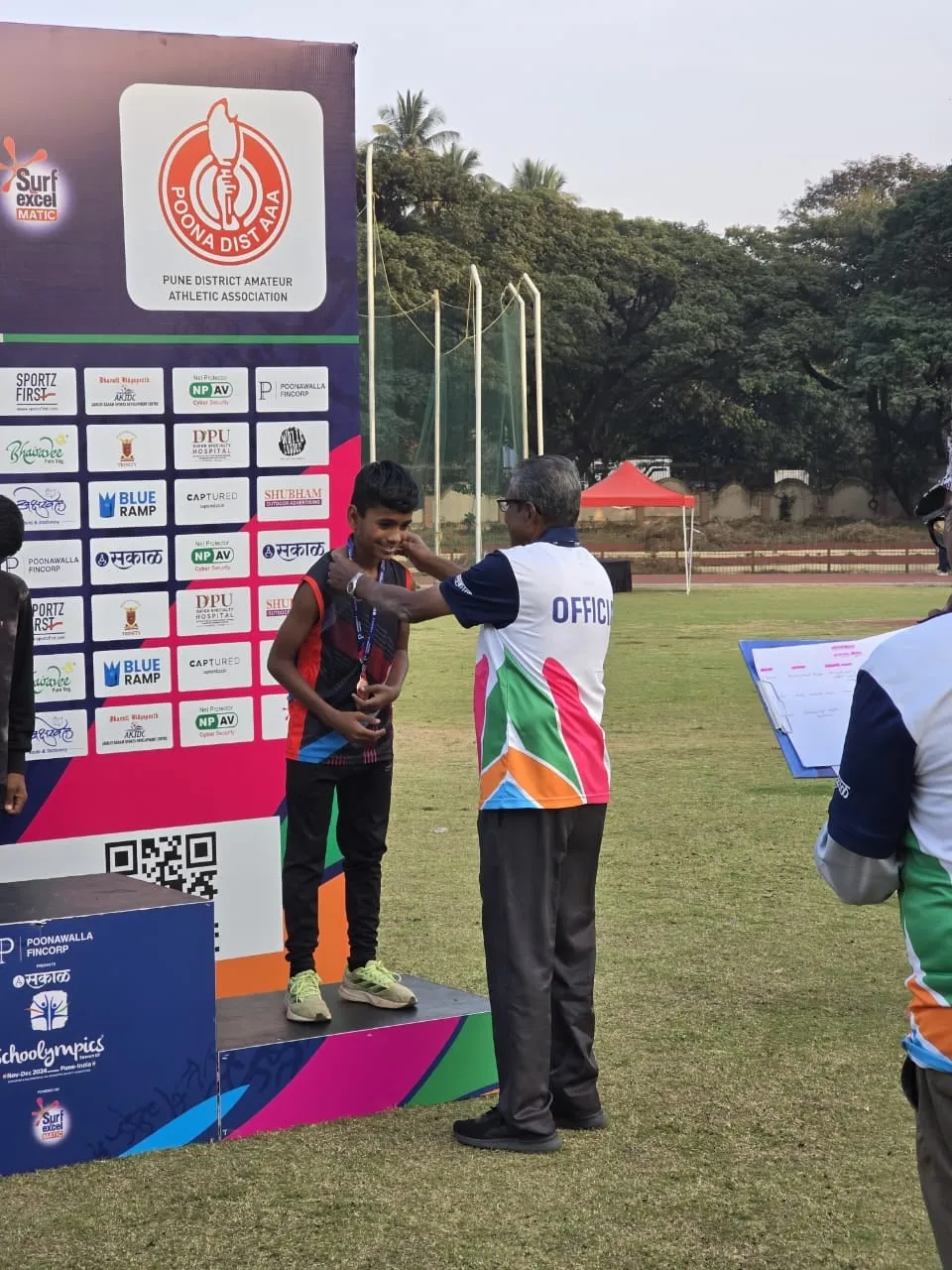 An official placing a medal on a young athlete