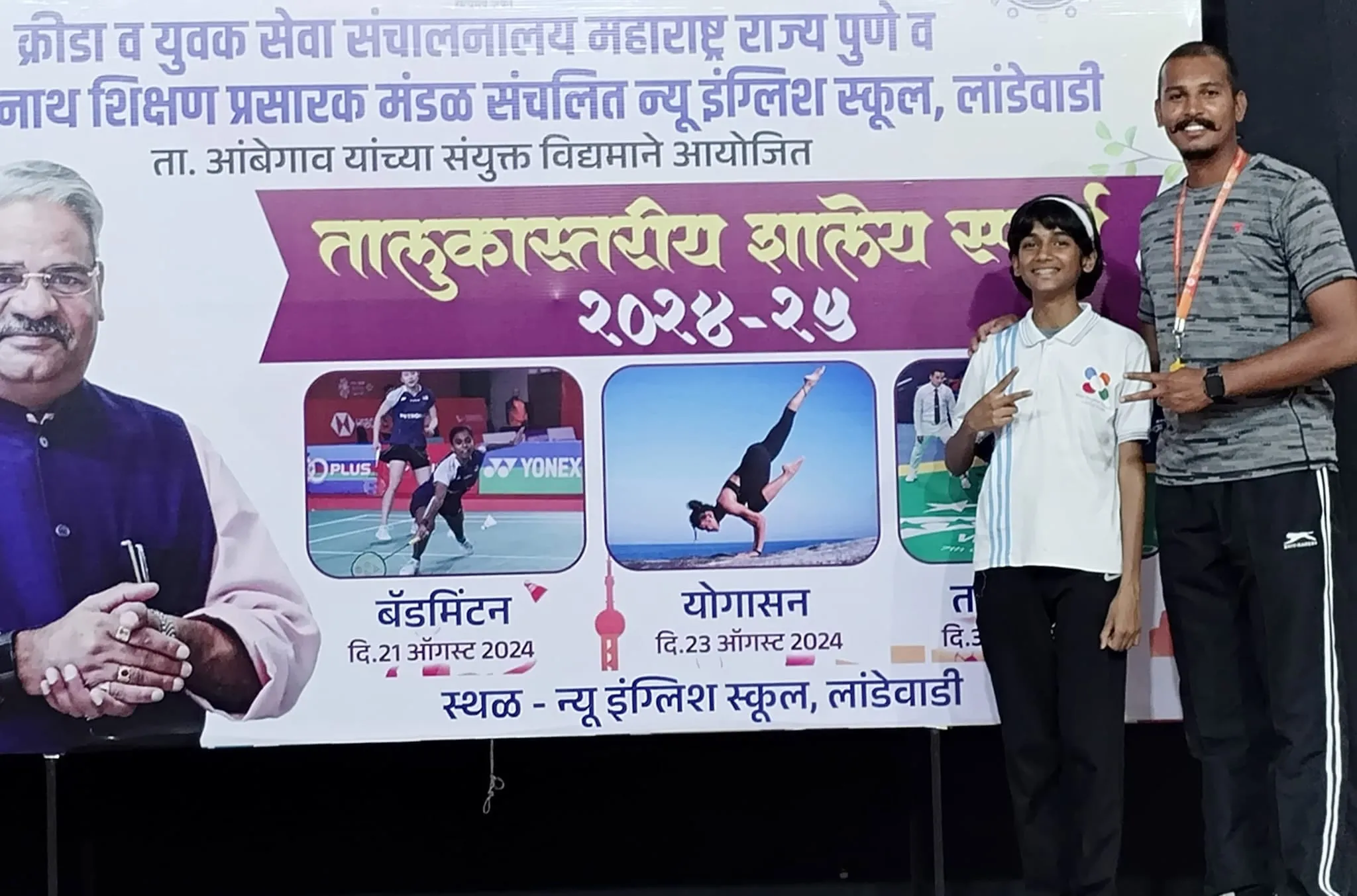 A student with her coach in front of the 2024-25 taluka-level school sports banner
