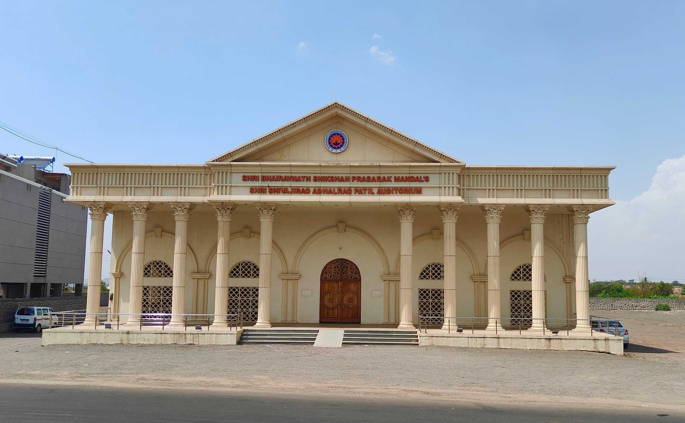 The columned front of the Shri Shivajirao Adhalrao Patil Auditorium on the SBSPM campus