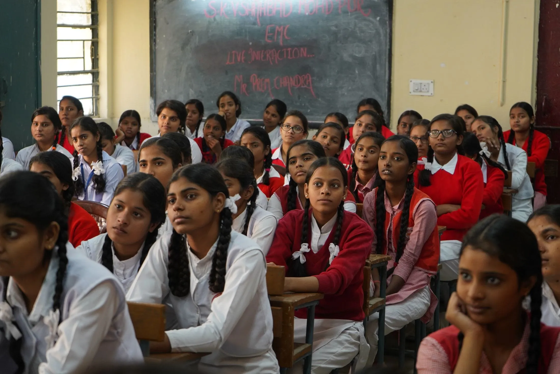 Schoolgirls in uniform listening in a classroom