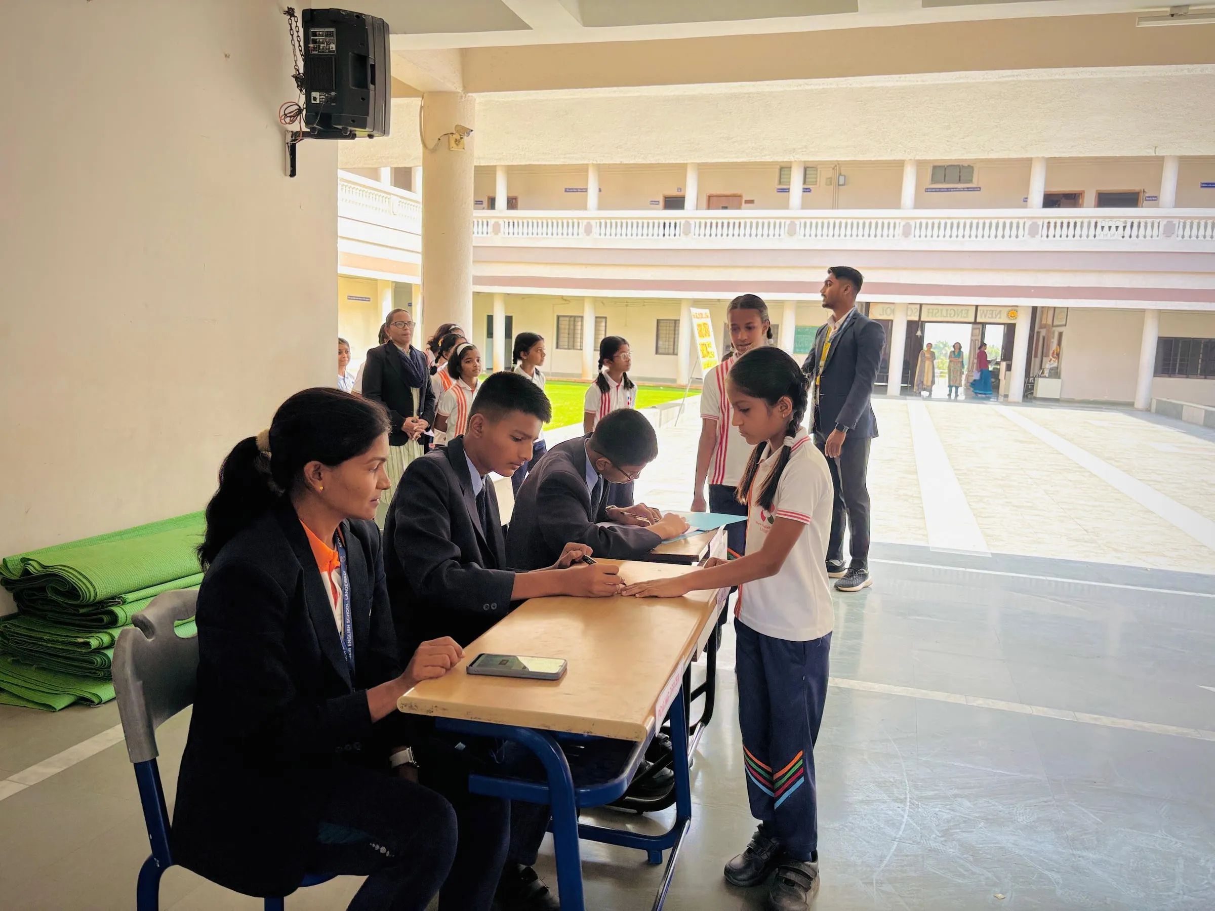 NES students voting in a school election at a desk in the courtyard
