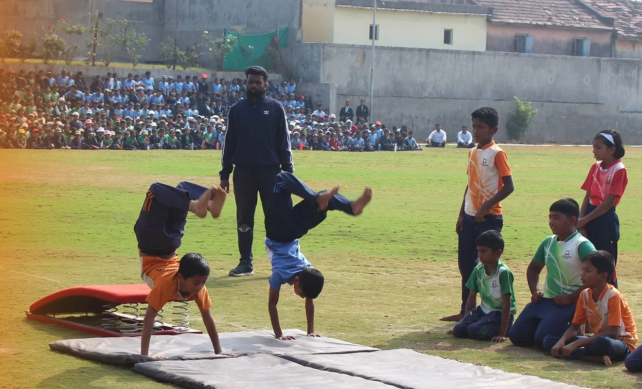 Students doing handsprings on mats on the sports ground