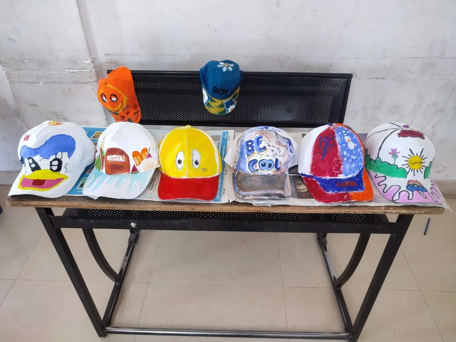 A row of hand-painted caps on a table