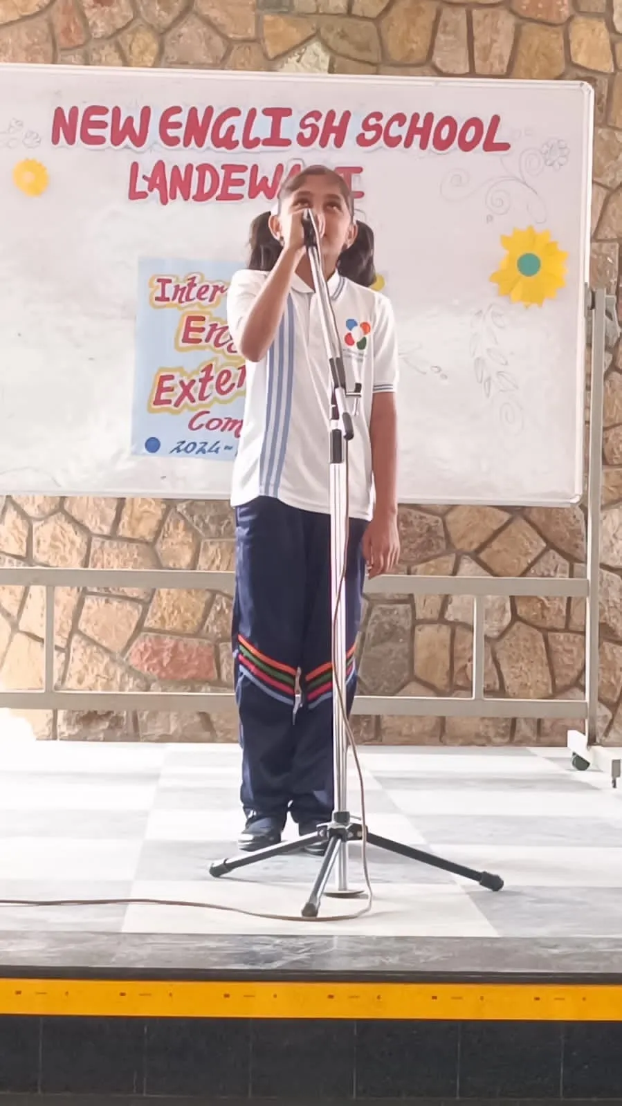 A student speaking at a microphone on stage