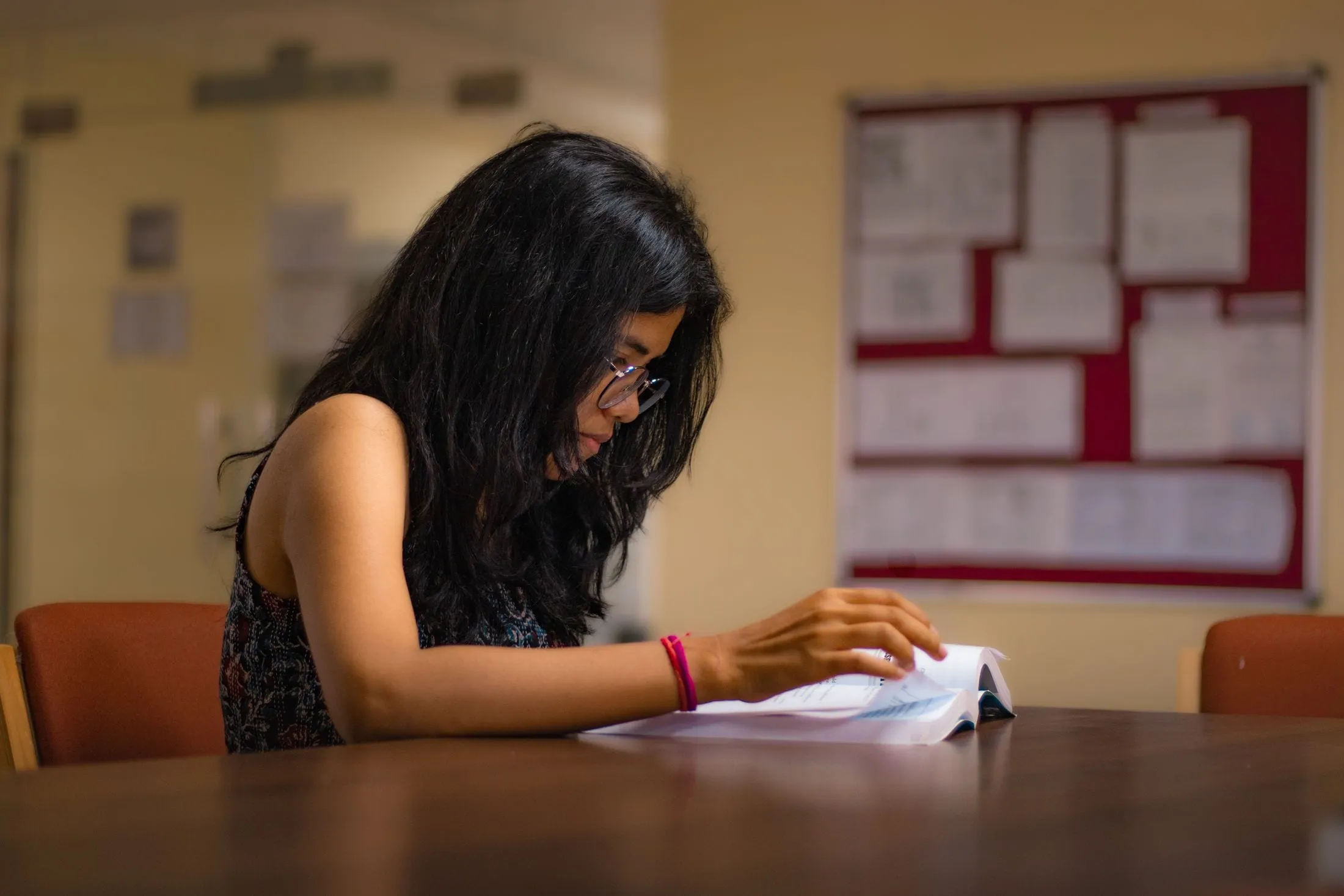 Student reading at a library desk