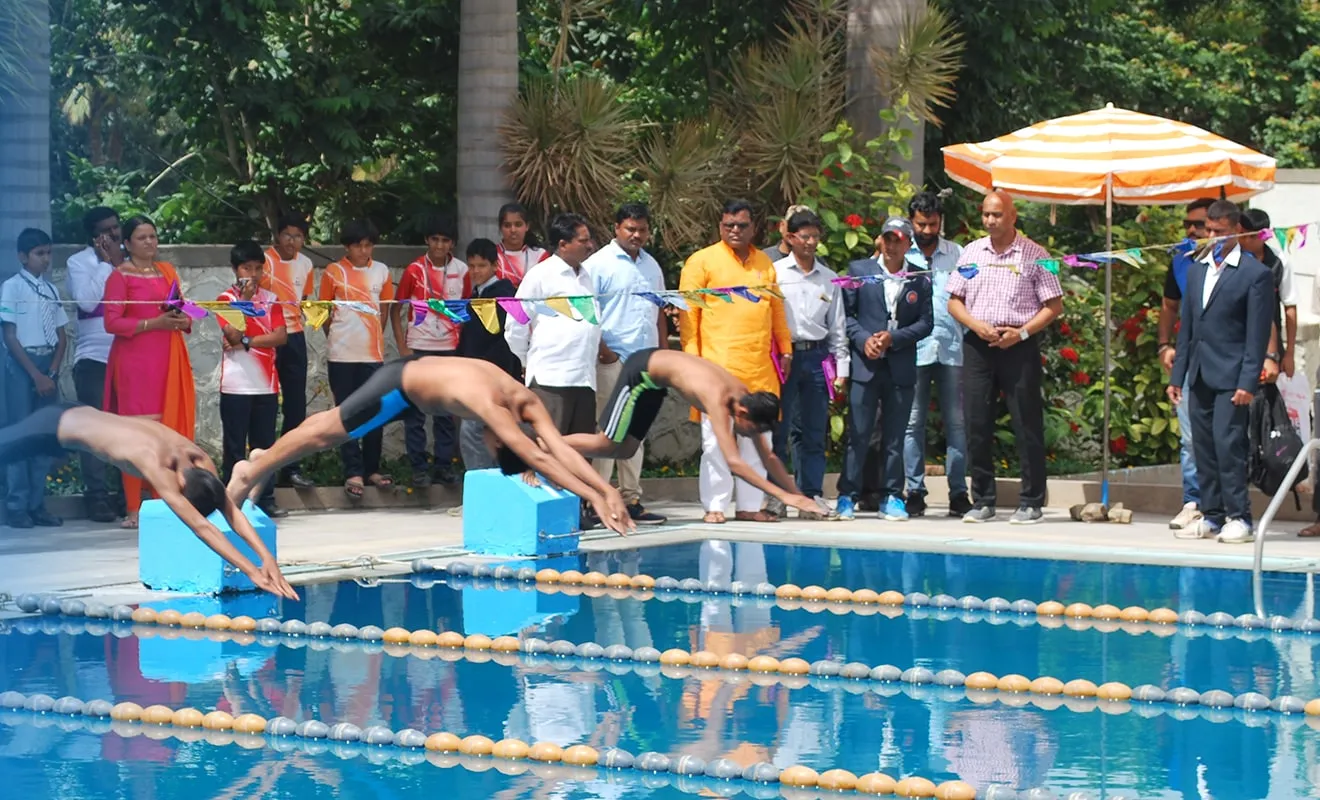 Students diving into the pool at the start of a race