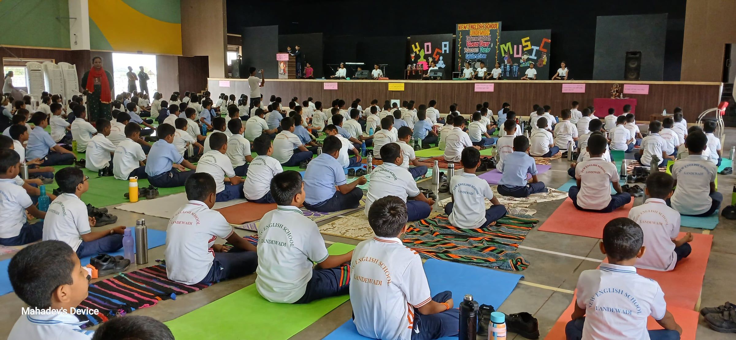 Hundreds of students on yoga mats in the school auditorium